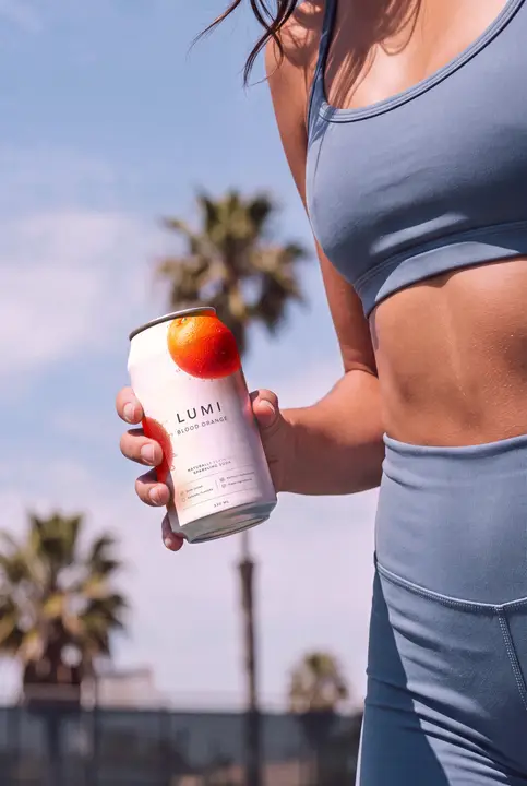 Soda Can Mockup Held by a Sporty Woman