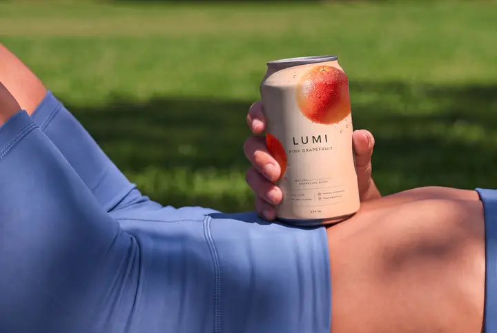 Soda Can Mockup Held by a Sporty Woman