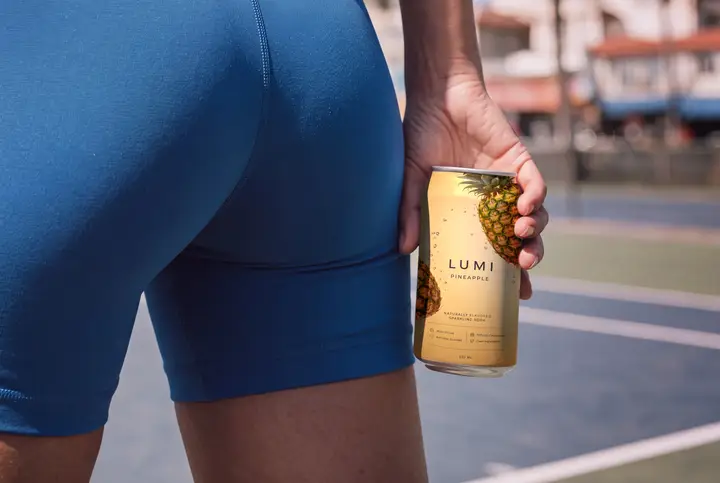 Soda Can Mockup Held by a Sporty Woman