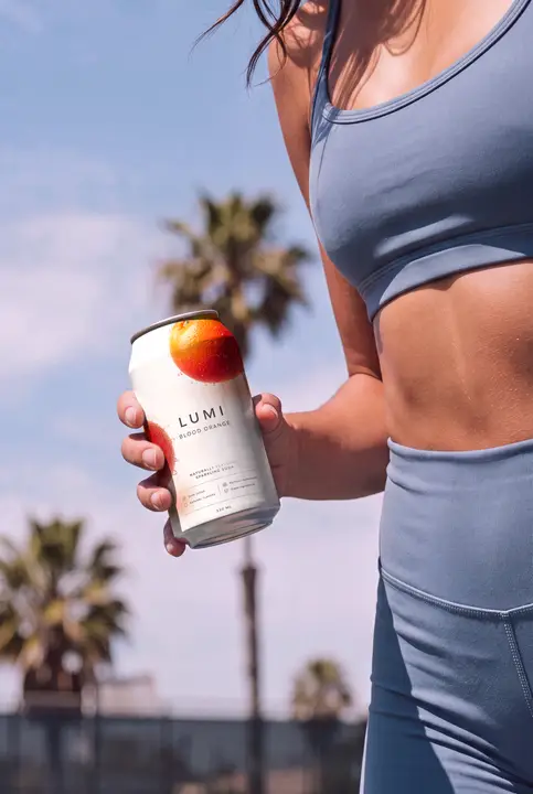 Soda Can Mockup Held by a Sporty Woman