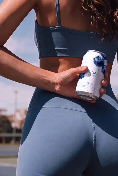 Soda Can Mockup Held by a Sporty Woman