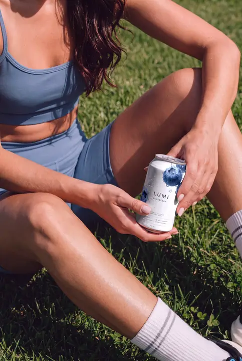 Soda Can Mockup Held by a Sporty Woman